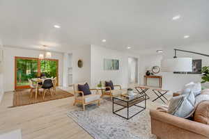 Living room with a notable chandelier and light wood-type flooring