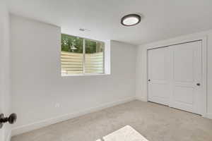 Unfurnished bedroom with a closet and light colored carpet