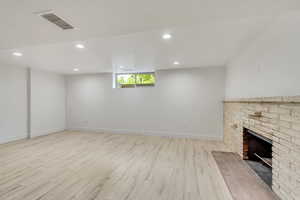 Unfurnished living room featuring a fireplace and light hardwood / wood-style floors