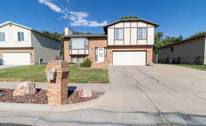 View of front facade featuring a front lawn and a garage