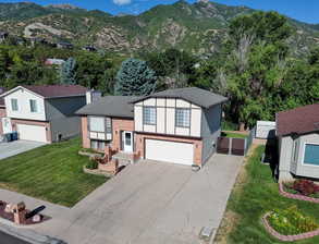 View of front of property with a front yard, a mountain view, and a garage