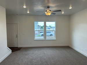 Carpeted spare room featuring ceiling fan