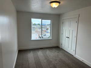 Carpeted empty room featuring a textured ceiling