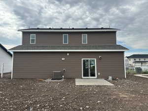 Rear view of property featuring central AC and a patio area