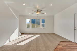 Empty room with ceiling fan and light hardwood / wood-style flooring