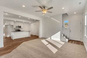 Living room with ceiling fan and dark hardwood / wood-style floors