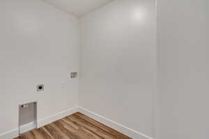 Laundry area with hookup for an electric dryer, washer hookup, and hardwood / wood-style flooring