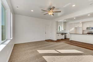 Unfurnished living room with ceiling fan, dark hardwood / wood-style floors, and sink