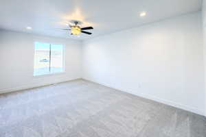 Carpeted empty room featuring ceiling fan