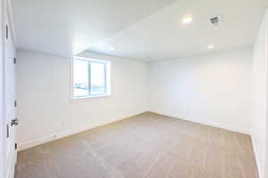 Carpeted spare room with a textured ceiling