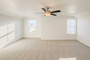 Bonus room featuring lofted ceiling, light colored carpet, and ceiling fan