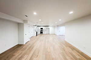 Unfurnished living room with sink and light wood-type flooring