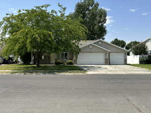 View of front with mature trees and 3 car garage