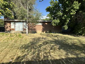 View of the back of the house from backyard featuring sliding glass door to living room