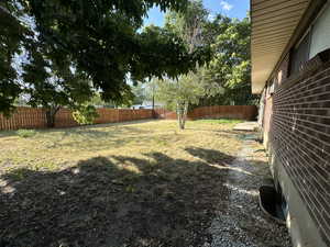 View of backyard featuring fully fenced, mature trees, fully automated sprinkling system