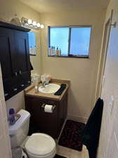 Primary bathroom with vanity, wall cabinet, tile flooring, and toilet