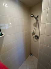 Primary bathroom featuring tiled shower