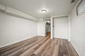 Interior space with wood-type flooring, a textured ceiling, and a closet