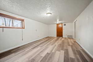 Spare room with hardwood / wood-style flooring and a textured ceiling