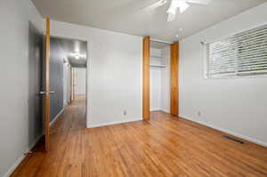 Unfurnished bedroom featuring ceiling fan, light hardwood / wood-style flooring, and a closet