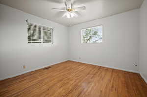 Empty room featuring ceiling fan and wood-type flooring