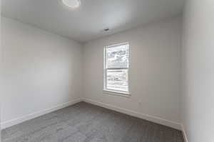 Carpeted spare room featuring a textured ceiling