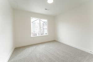 Unfurnished room featuring light carpet, baseboards, and visible vents