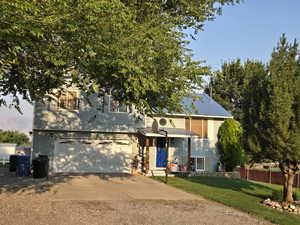 View of front facade with a garage and a front lawn