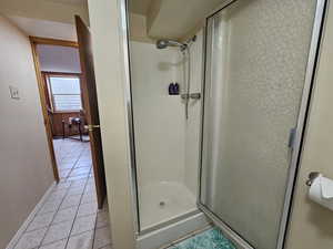 Bathroom featuring a shower with shower door and tile patterned flooring