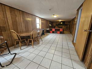 Dining area with wooden walls and light tile patterned floors