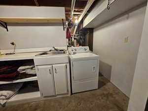 Laundry room with sink, washer / dryer, and cabinets