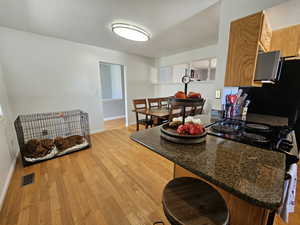 Kitchen with a breakfast bar area, light wood-type flooring, and kitchen peninsula