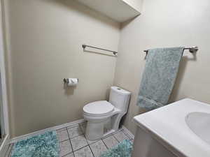 Bathroom featuring vanity, tile patterned flooring, and toilet