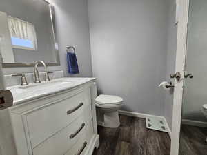 Bathroom featuring wood-type flooring, vanity, and toilet