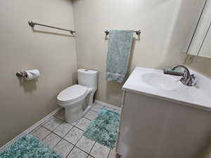 Bathroom with vanity, toilet, and tile patterned flooring