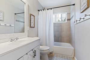 Full bathroom with shower / bath combo, toilet, vanity, and tile patterned flooring