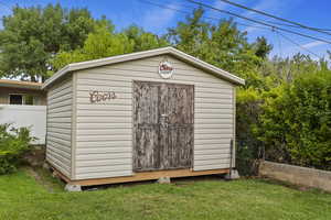 View of outbuilding with a yard