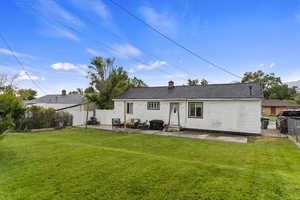 Back of house with a patio and a yard