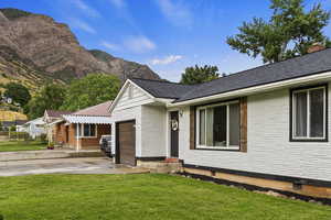 View of the front of property featuring a front yard, a mountain view, and a garage