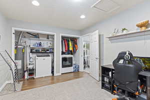 Home office with washer / clothes dryer, light wood-type flooring, and gas water heater