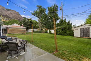 View of yard featuring a mountain view, a patio area, and a storage unit