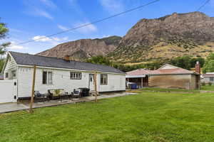 Back of house with a yard, a patio, a mountain view, and outdoor lounge area