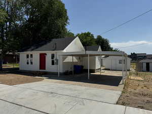 View of front of house with a carport and a storage unit