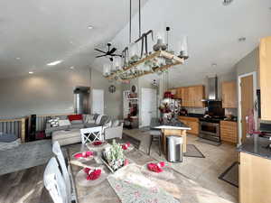 Dining area with high vaulted ceiling, light wood-type flooring, and ceiling fan