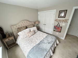 Carpeted bedroom featuring a closet