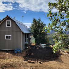 View of side of home featuring an outbuilding