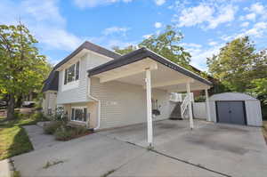 View of side of property featuring a storage shed and a carport