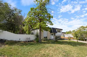 View of side of home featuring a yard