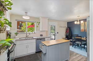 Kitchen with sink, plenty of natural light, stainless steel appliances, and light hardwood / wood-style flooring