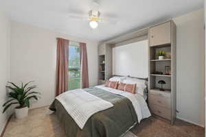 Bedroom with ceiling fan and light colored carpet